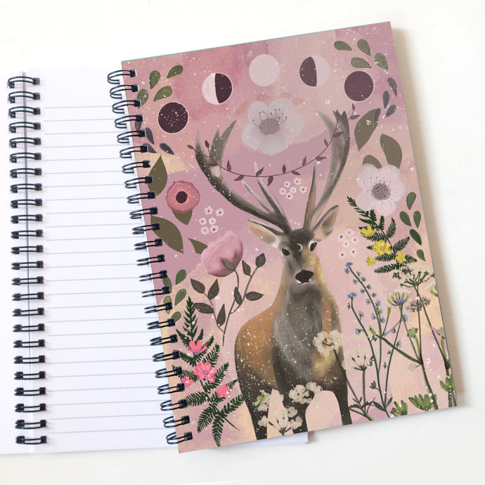 A stag notebook with pink flowers and moon phases